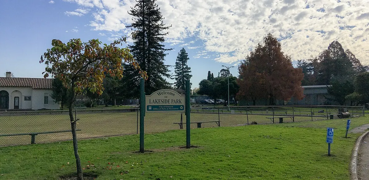 The park sign, trees and grass in Lakeside Park, Oakland.