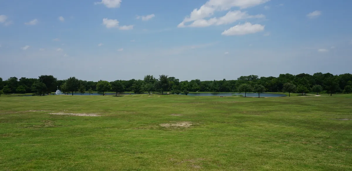 Open lawn, trees and pond at Frisco Commons Park in Frisco.