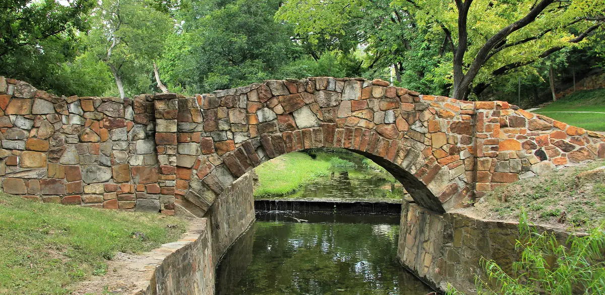 A stone bridge over Turtle Creek in Reverchon Park in Dallas.